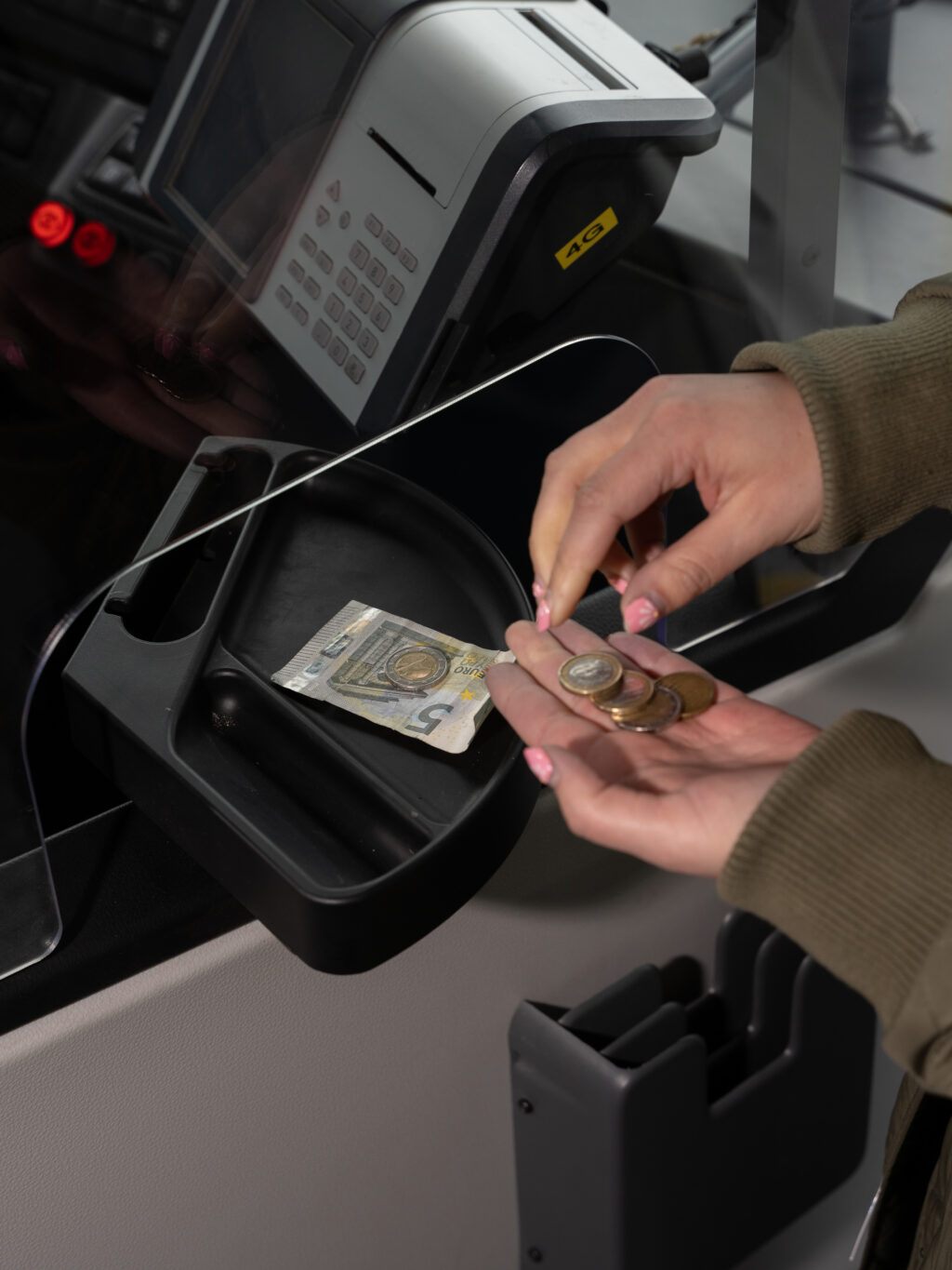 asiakas maksamassa bussilippua setelillä ja kolikoilla