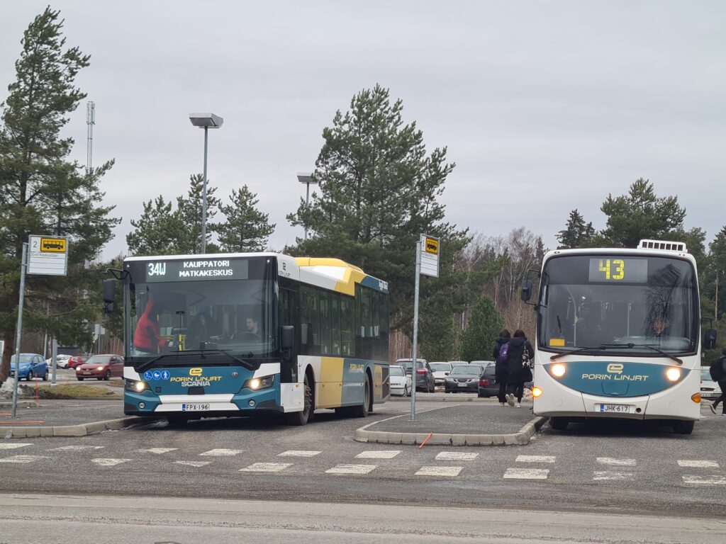 kaksi bussia laitureissa odottamassa matkustajien kyytiinnousua
